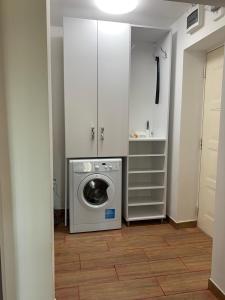 a laundry room with a washing machine and a washer at Alex Apartament in Mangalia