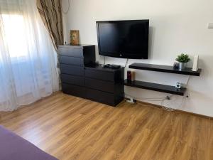 a living room with a tv and a wooden floor at Alex Apartament in Mangalia