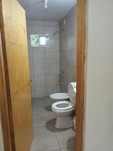 a bathroom with a toilet and a window at Don Omar in Posadas