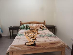 una cama con un tigre en ella con dos mesas en Don Omar en Posadas