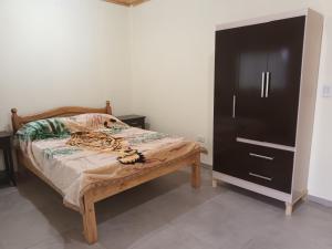 um quarto com uma cama e um armário preto em Don Omar em Posadas