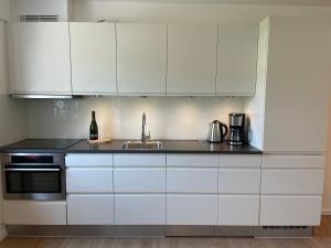 a kitchen with white cabinets and a sink at NEU 2023 - Fewo mit Meerblick & Flair in Harrislee