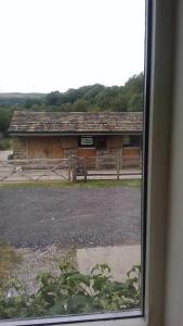 uma vista para um celeiro a partir de uma janela em Millstone cottage em Oldham