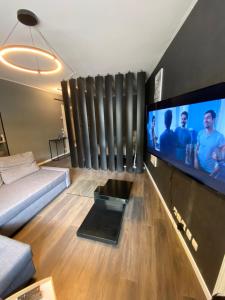モンティニー・ル・ブルトンヌーにあるSuite full Confort Netflix Wifiのリビングルーム(ソファ、大画面薄型テレビ付)