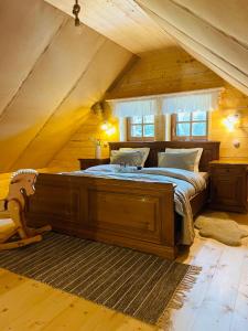 ein Schlafzimmer mit einem Holzbett im Dachgeschoss in der Unterkunft Hájenka Libín in Prachatice
