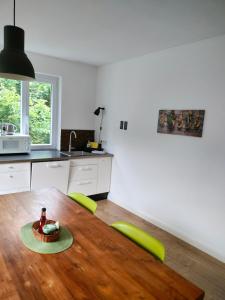 cocina con mesa de madera y sillas verdes en Gartenblick en Reichenberg