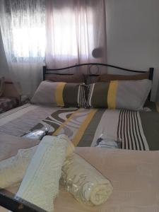 a bed with some blankets and pillows on it at Marilyn's Cottage in Sozopoli Chalkidiki in Sozopoli