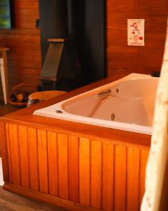 uma banheira na casa de banho com paredes de madeira em Pousada Rosa Maria em Erechim