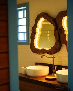 uma casa de banho com um lavatório e um espelho num balcão em Pousada Rosa Maria em Erechim