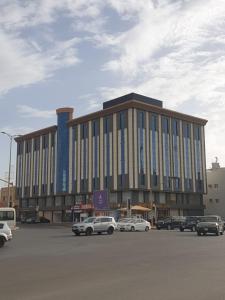 un grand bâtiment avec des voitures garées dans un parking dans l'établissement المهيدب للوحدات السكنيه -رابغ, à Rabigh