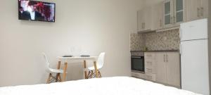 een witte keuken met een tafel en een witte koelkast bij 2downtown.skg in Thessaloniki