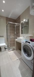 een badkamer met een wasmachine en een wastafel bij 2downtown.skg in Thessaloniki