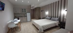 een slaapkamer met een bed, een bureau en een keuken bij 2downtown.skg in Thessaloniki