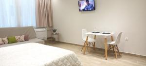 een kamer met een bed en een tafel met stoelen bij 2downtown.skg in Thessaloniki