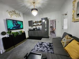 Quantock Lodge Vicarage 2 في روتشستر: غرفة معيشة مع أريكة وتلفزيون بشاشة مسطحة