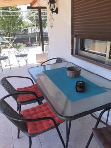 a glass table and chairs with a watch on it at Marilyn's Cottage in Sozopoli Chalkidiki in Sozopoli