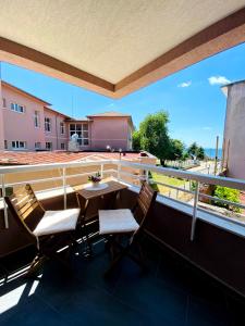 een balkon met een tafel en stoelen op een dak bij DiP HOME APARTMENTS in Pomorie