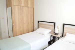 a bedroom with two beds and a night stand at Maison Nikola Kanali in Kanali