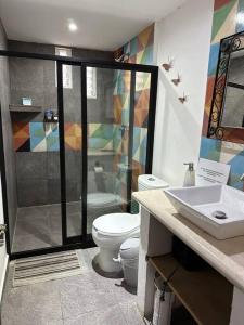 uma casa de banho com um chuveiro, um WC e um lavatório. em Departamento Mariposas em Oaxaca de Juárez