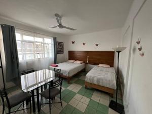 a bedroom with two beds and a table and a dining room at Departamento Mariposas in Oaxaca City
