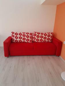 a red couch in a room with two red pillows at Denize Yakın Daire in Antalya