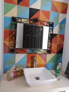 a bathroom with a sink and a mirror on a wall at Departamento Mariposas in Oaxaca City