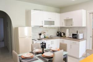 a kitchen with white cabinets and a table with plates on it at Maison Nikola Kanali in Kanali