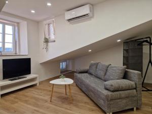 a living room with a couch and a tv at Apartment and Room Marija in Krk
