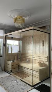 a large glass shower in a room with a chandelier at Ośrodek Wczasowy REWA in Rewa