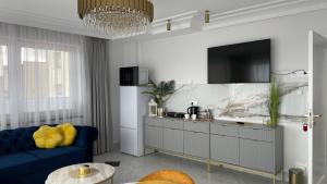 a living room with a blue couch and a tv at Ośrodek Wczasowy REWA in Rewa