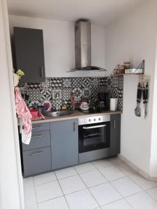 a kitchen with a sink and a stove at La hervuerie in La Haye-du-Puits