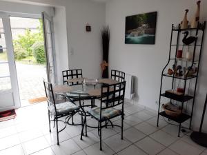a dining room with a glass table and chairs at La hervuerie in La Haye-du-Puits