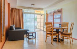 een woonkamer met een bank en een tafel en stoelen bij Jacana Amazon Wellness Resort in Paramaribo