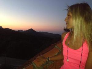 a woman in a pink shirt standing on top of a mountain at Traditional Rooms Elena in Astirákion