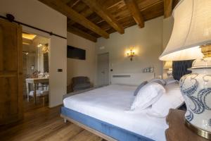 a bedroom with a large white bed with a lamp at Tenuta Bussia - Wine Relais & Spa in Monforte dʼAlba