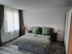 Un dormitorio con una cama grande con almohadas verdes. en FeWo - Zur Alten Wäscherei - Zentrumsnah - Garage inklusiv, en Stuttgart