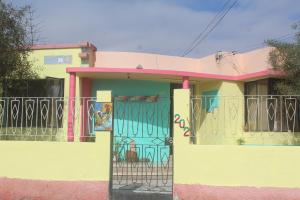 una casa colorida con una puerta con graffiti. en Hostel Posada de Gallo en Arica