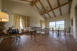 een grote woonkamer met een tafel en stoelen bij Tenuta Bussia - Wine Relais & Spa in Monforte dʼAlba