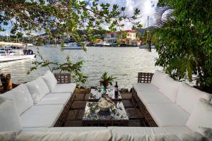a living room with white couches next to the water at Harmony Marina Suites in Rodney Bay Village