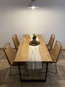 une table en bois avec des chaises et une plante en pot. dans l'établissement Tu depto en Mardel, à Mar del Plata