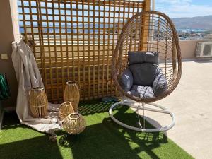 a wicker chair sitting on top of a balcony at Penthouse360view in Karistos
