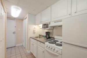 a kitchen with white cabinets and a stove top oven at Studio w Balcony and Ocean View - Boardwalk One - 203 in Ocean City