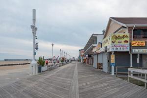 a boardwalk on a beach with restaurants and a pier at Studio w Balcony and Ocean View - Boardwalk One - 203 in Ocean City
