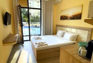 a small bedroom with a bed and a balcony at Stamopolu Lux ground floor in Primorsko +27 photos
