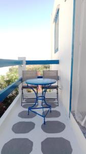 ein Tisch und zwei Stühle auf einem Balkon in der Unterkunft Molos Pine view in Molos Parou