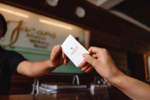 uma pessoa segurando um pedaço de papel em suas mãos em Jacana Amazon Wellness Resort em Paramaribo