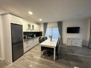 a kitchen with a table and a black refrigerator at M&S Apartament 1 in Baile Felix +3 photos