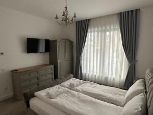 a bedroom with a bed and a dresser and a window at M&S Apartament 1 in Baile Felix