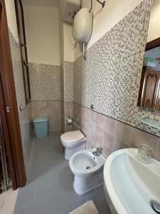 uma casa de banho com um WC branco e um lavatório. em Martino10 em Carloforte