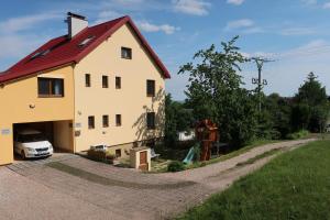 a house with a car parked next to a driveway at Apartmány U Zvoničky in Prachov